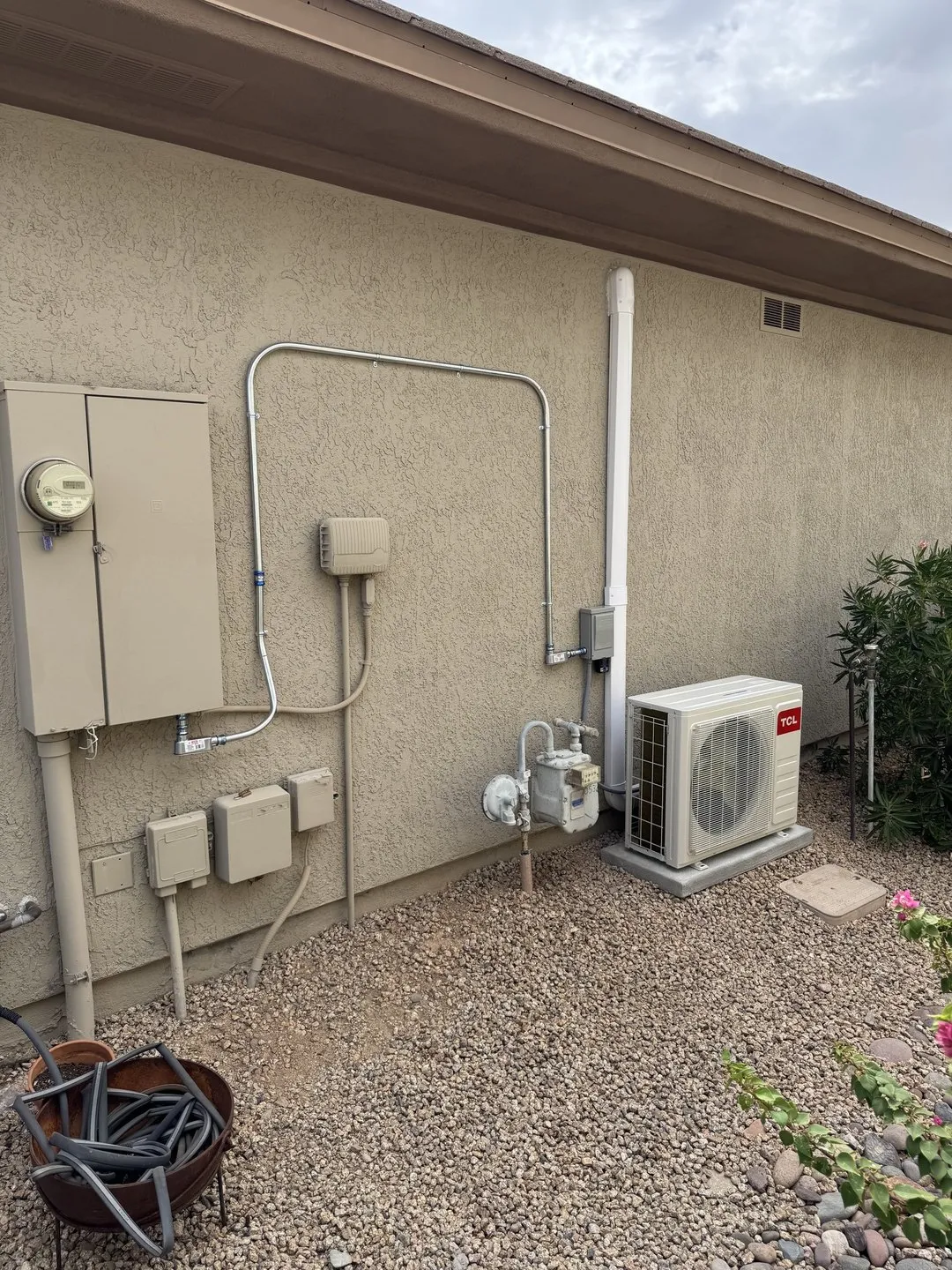 A ductless mini-split outdoor unit installed on a stucco wall with clean line-set cover